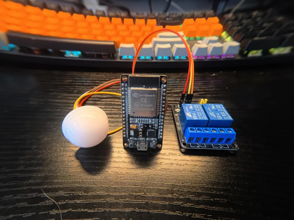 ภาพถ่ายอุปกรณ์อิเล็กทรอนิกส์ประกอบด้วยบอร์ด ESP32 DevKit V1, โมดูลรีเลย์ 2 ช่อง และเซนเซอร์bh1750 วางบนโต๊ะไม้สีเข้ม ใช้ในการสาธิตโครงงานควบคุมไฟอัตโนมัติด้วย ESP32